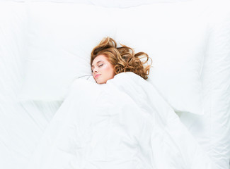 Shot of a young woman sleeping on a bed .