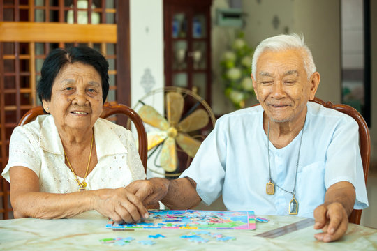 Couple senior playing with a jigsaw puzzle at home
