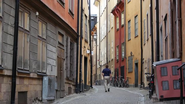 Man walking in a street in Gamla Stan Old town Stockholm Sweden