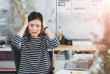 Fototapeta na wymiar Beautiful young Asian girl feeling headache and stress in office space background.Concept of Healthcare and Office syndrome.Vintage tone