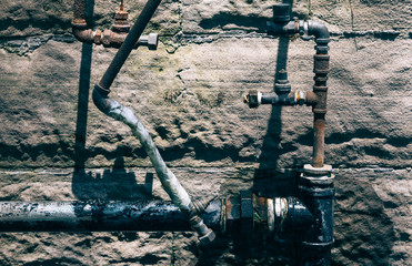 detail of rusty water pipes against wall.