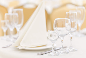 A set table in the restaurant with empty glasses and cutlery decorated with napkins.