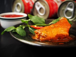 Canned fish on black background