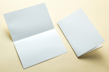 Empty paper flyers, business cards, brochures on a yellow background, layout. Space for text.