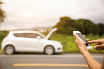 Using a mobile phone call a car mechanic because car was broken.