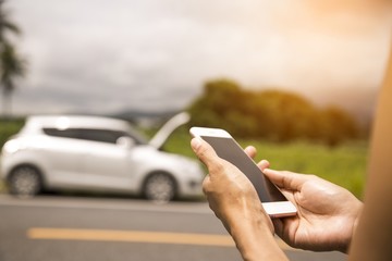 Using a mobile phone call a car mechanic because car was broken.