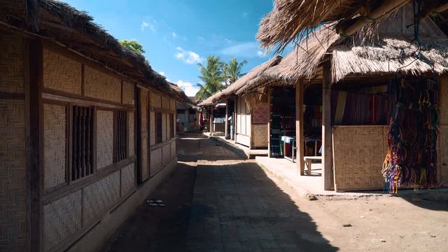 Street of Sasak Sade traditional weaving village in Lombok with bamboo houses and grass roofs. Shot with Sony a7s and Atomos Ninja Flame on sunny day with blue sky.