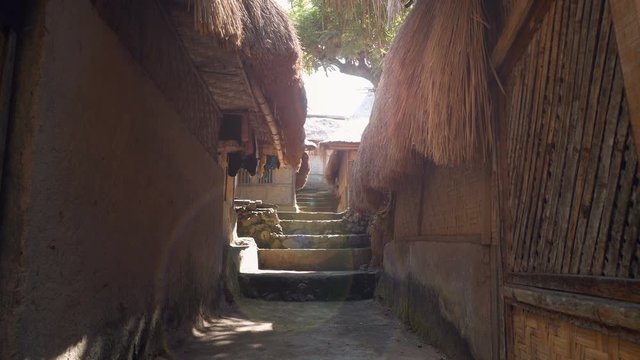 Narrow street with stairs in Sasak Sade traditional weaving village in Lombok with bamboo houses and grass roofs. Shot with Sony a7s and Atomos Ninja Flame on sunny day.