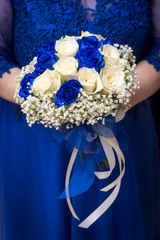 Buoquet sposa rotondo di rose avorio e blu in mano alla sposa
