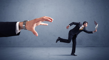 Businessman running from hand