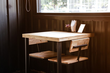 Wooden table by near glass window for eating.