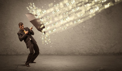 Business man holding umbrella against dollar rain concept