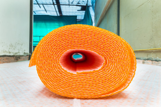 Orange Roll Of Membrane Waterproofing, Separation And Steam Escape.  Drainage System For Floor Of Terrace - Roof, With Fiber Fabric. The Sheath Roll Is Resting On Rolls Already Laid