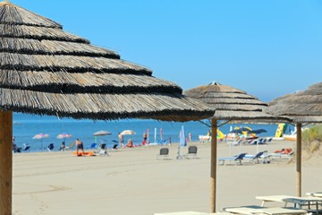 Large straw beach umbrella to shelter from the hot summer sun