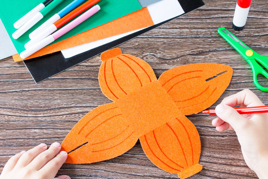 Create a gift box of Halloween pumpkin. The child draws details of the application of the box. Children's art project, craft for children. Craft for kids.
