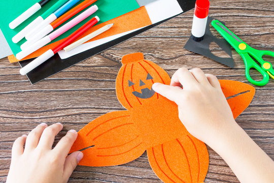 Create a gift box of Halloween pumpkin. The child glues the details of the application of the box. Children's art project, craft for children. Craft for kids.