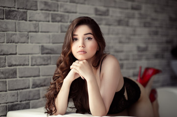 charming brunette woman with long hair on sofa