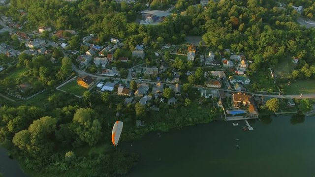 Aerial Paraplane hang glider in the air above river city canyon