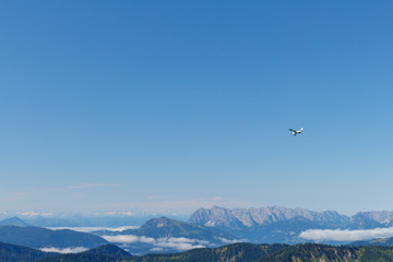 small prop plane above Mountains in Bavaria, view from Mt. Hochfelln on a summer day sunrise