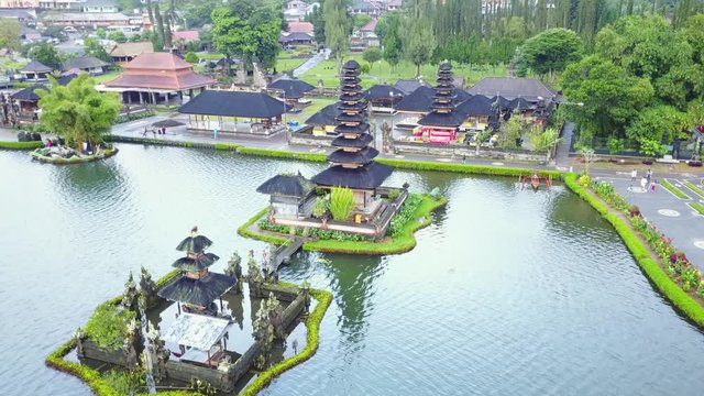 Beautiful aerial landscape footage of Ulun Danu Bratan Temple from a drone flying backward in Tabanan, Bali, Indonesia. Shot in 4k resolution