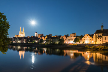 Nachtaufnahme von Regensburg mit Mond neben dem Dom