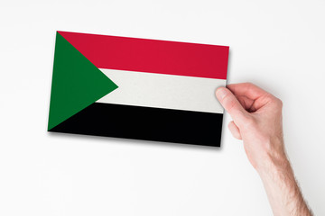 Male hand holding sudan flag