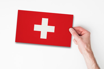 Male hand holding switzerland flag