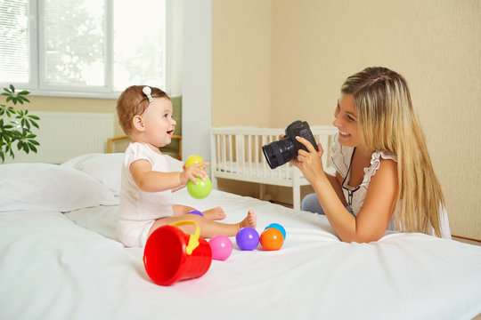 Mother  Photographer Photographing Of Her Baby On Camera.