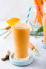 Healthy breakfast with carrot smoothie with orange and cinnamon in glass jar and ingredients. Detox, diet, healthy, vegetarian food concept.