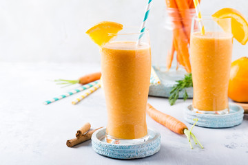 Healthy breakfast with carrot smoothie with orange and cinnamon in glass jar and ingredients. Detox, diet, healthy, vegetarian food concept with copy space.