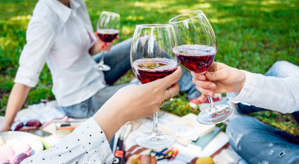 Young beautiful girls with glass of red wine in the park