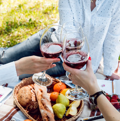 Young beautiful girls with glass of red wine in the park