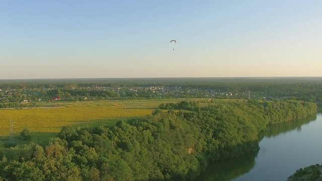 Aerial Paraplane hang glider in the air above river city canyon