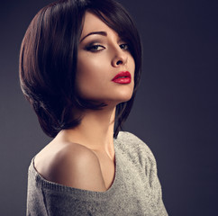 Beautiful makeup sexy woman with short hair style with hot red lipstick on dark shadow background....