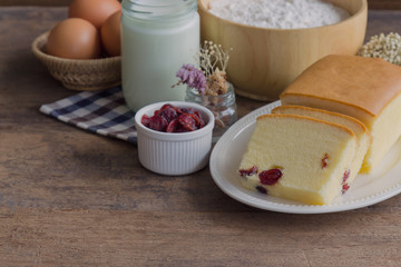 Obraz na płótnie Canvas Slices of butter cake on white plate. Homemade butter cake with dried cranberries so delicious soft and moist. Tasty pound cake or butter cake served on wood table. Homemade bakery background concept.