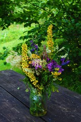 Wildflowers in a jar on a wooden table