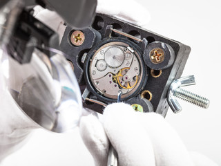watchmaker in head-mounted magnifier repairs watch