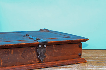 Vintage closed wooden chest box. Old wooden box on a wooden and blue background.