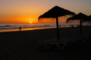Silhouettes at sunset on the beach of La Barrosa, Sancti Petri, Cadiz, Spain