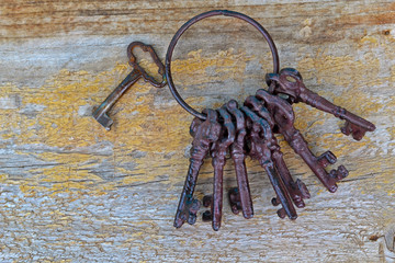 Old ornate skeleton keys on rough wood background. A bunch of antique keys on wooden background.