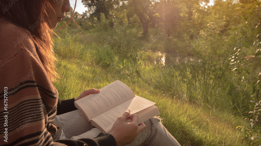 Wall mural the woman reading the book at nature.