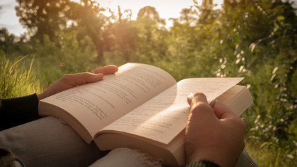 Close up the woman's hand while reading the book.