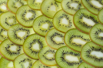 Bright green background with slices of juicy kiwi. Healthy food background.