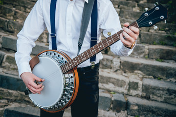 View of musician playing banjo at the street