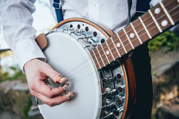 View of musician playing banjo at the street - obrazy, fototapety, plakaty