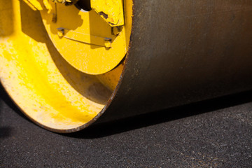 Pavement machine laying fresh asphalt or bitumen on top of the gravel base during highway construction