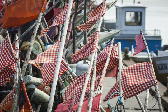 Network fishing drying on the beach in sunny day. Baltic Sea and fishing boats in background. Krynica Morska, Poland.