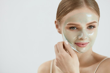 Face Mask. Closeup Beautiful Girl Removing Mask From Skin