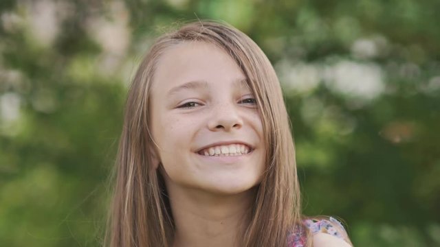 Girl teenager face close-up with freckles and funny posing embarrassed and playing with his hair.