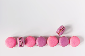 Row of colorful french macarons on white background. Top view.